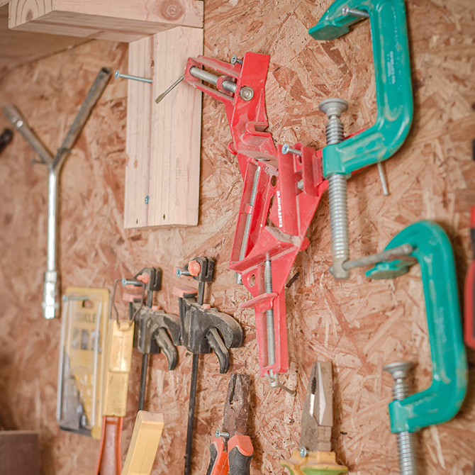 Various woodworking tools hanging on wall organizer