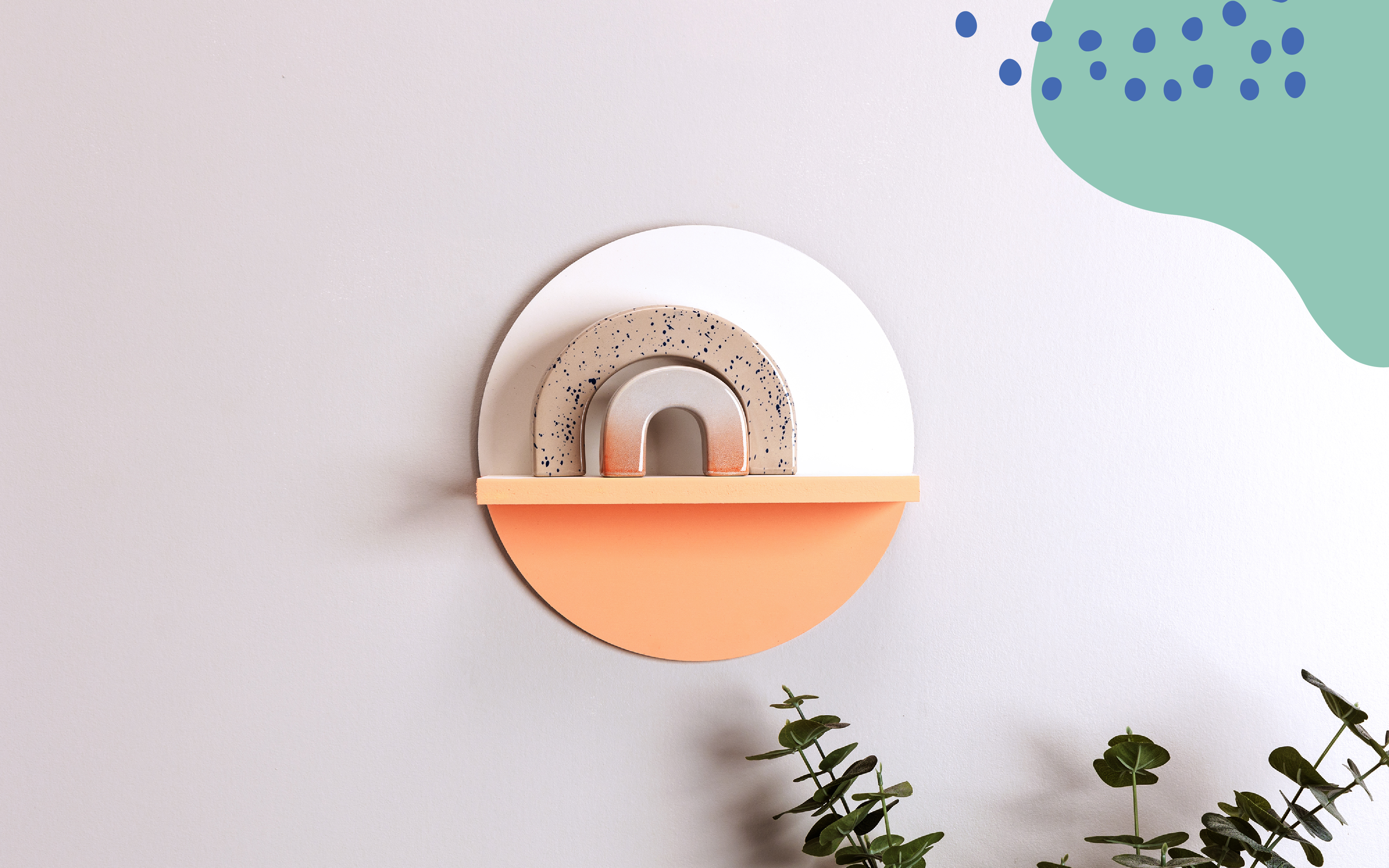 Right Home Page Hero - Plywood circle shelf with arches wall decor and Handprint green shape with blue dots in upper right
